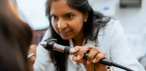 Doctor performing an examination on a patient in a medical exam room.