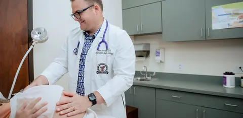 Doctor performing an examination on a patient in a medical exam room.