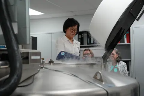 CPRIT Kand Lab tour large equipment with steam and professor wearing a glove reaching inside.