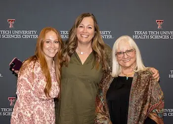 Three women posing at the 10 year FMAT celebration for school of medicine.