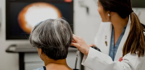 Doctor performing an examination on a patient in a medical exam room.