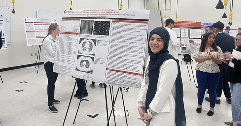 woman standing in front of a research presentation poster