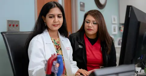 two health professionals look at a model of a heart