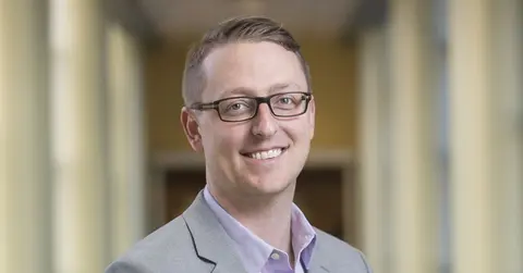man smiling standing in hallway