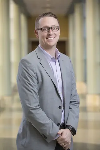 Man smiling standing in hallway