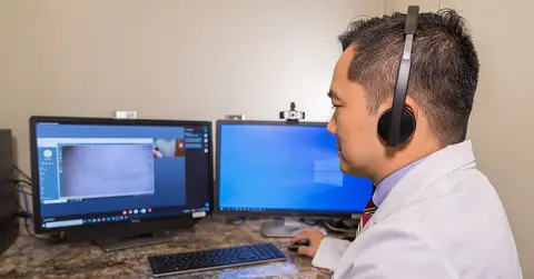 Ariel Santos, M.D., working with telehealth resources