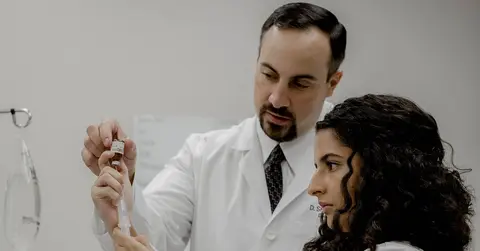Shane Harper, DMS, PA-C, working with a woman in a lab