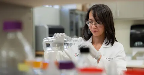 Ninh (Irene) La-Beck, Pharm.D., using tools in a lab