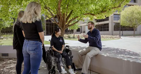 occupational therapist with patients in wheelchairs outside
