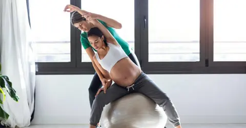 pregnant woman exercises with a physical therapist