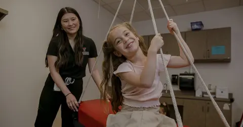 health care professional and young girl on swing