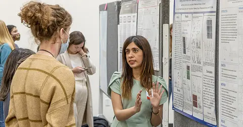 student giving poster presentation during student research week