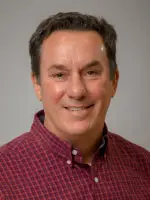 Man smiles for headshot.