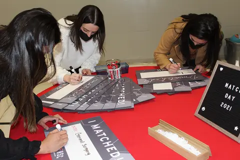 Students write on boards for Match Day 