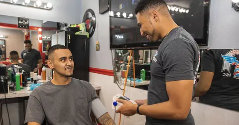 Student tests blood pressure of man