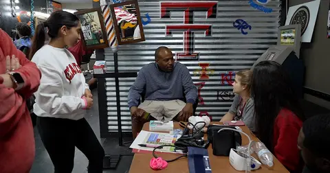Students and clients at local Lubbock barbershop discuss health topics