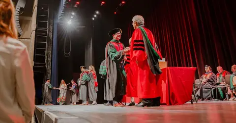 TTUHSC School of Medicine student crossing the stage at graduation