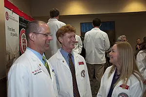 Ronald Cook, D.O., speaks with FMAT students Clay Buchanan and Keeley Bramblett after a press conference introducing them and their classmates to the community.