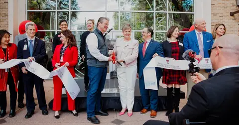 TTUHSC leadership cutting a large ribbon in front of the new Dallas campus building