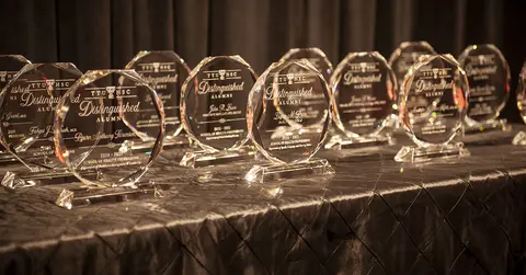 Distinguished Alumni awards lined up on a table