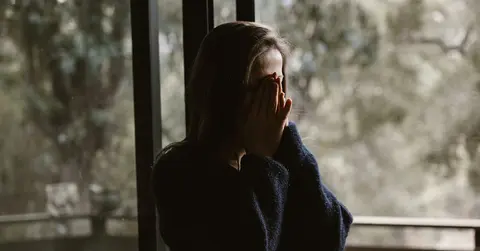 distressed woman with her head in her hands