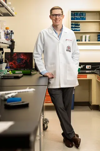 Bradley Schniers standing in lab.