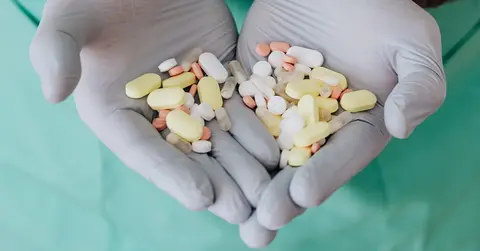 hands holding an assortment of medication