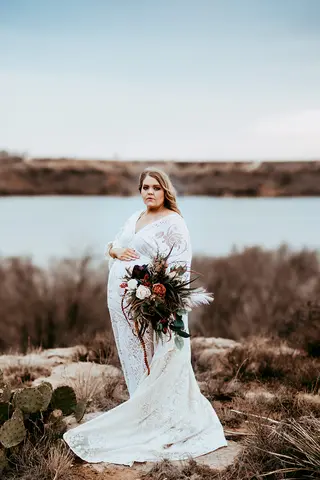 Megan McCrory in a white dress standing outdoors
