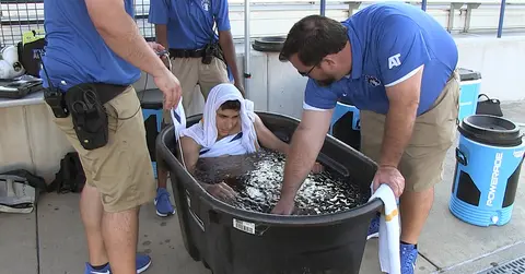 athletic trainers giving a patient an ice bath