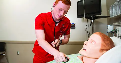 Nursing student in a training lab, what makes a great nurse?