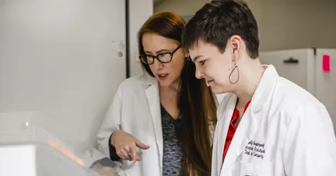 A teacher and student looking at lab work together