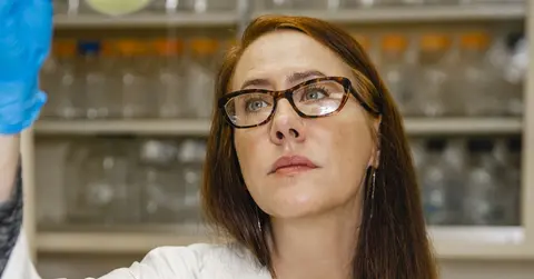 Kendra Rumbaugh, Ph.D., looking at a vile in a lab