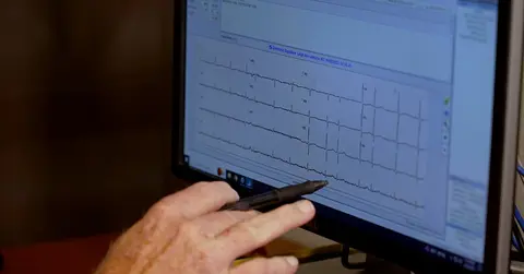 Scott Shurmur, M.D. examines an EKG