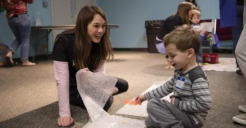 woman playing with child in health care setting