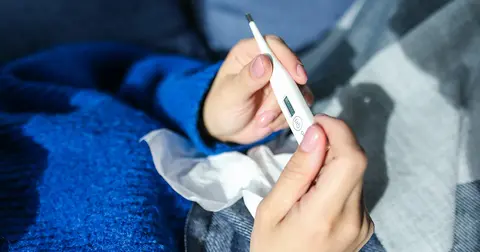 hands holding a thermometer