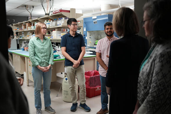 CPRIT members meeting graduate students in the lab talking with each other.