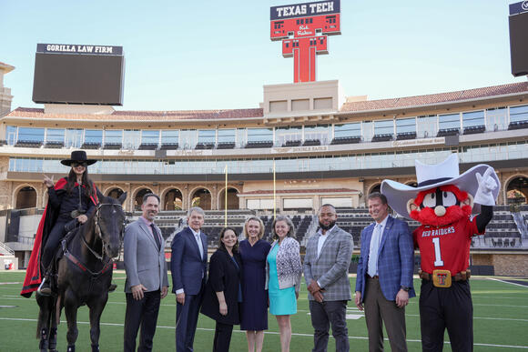 CPRIT leadership McMahon Reecy with Raider Red and The Masked Rider on the Texas Tech Galaxy Stadium football field.