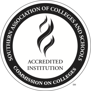 Official institutional accreditation stamp of the Southern Association of Colleges and Schools Commission on Colleges (SACSCOC). The circular blue and white logo features a central flame torch surrounded by concentric rings bearing the text "SOUTHERN ASSOCIATION OF COLLEGES AND SCHOOLS" and "COMMISSION ON COLLEGES," with "ACCREDITED INSTITUTION" highlighted in the middle.