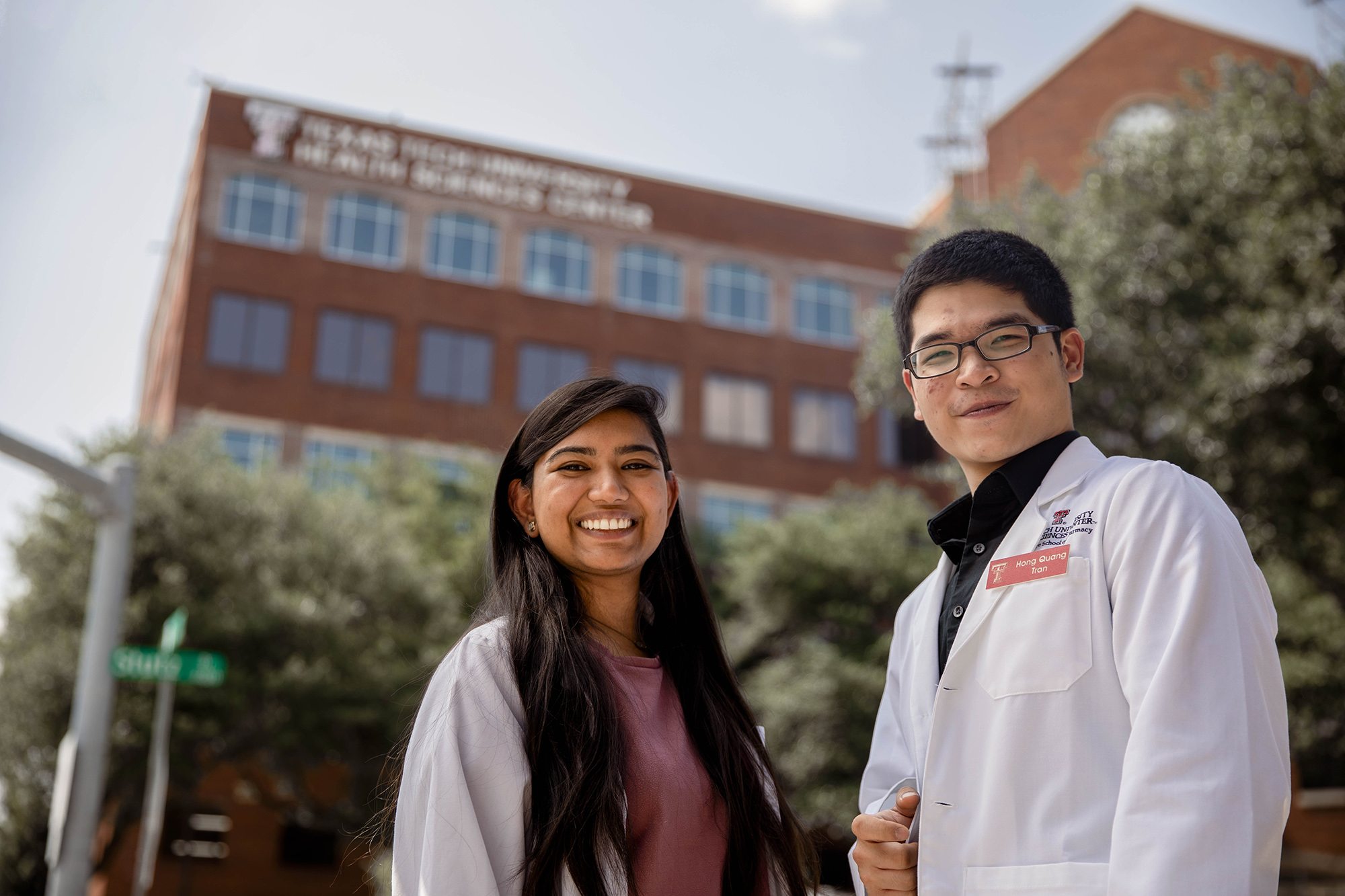 Two students smiling in front of the Dallas campus building