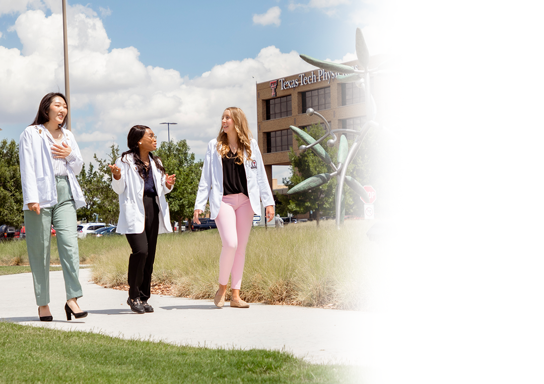 Three medical student walking out in the front of the campus